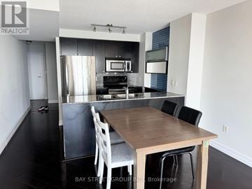 Toronto (Waterfront Communities) condo for rent - A kitchen with a table and chairs in the foreground.