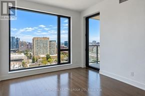Ottawa condo for rent - A room with a view of the city skyline through large windows.
