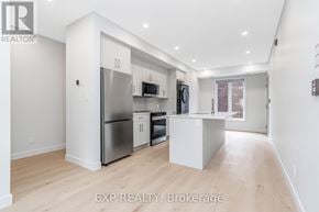 Ottawa multi-family for rent - A modern kitchen with stainless steel appliances and a wooden floor.
