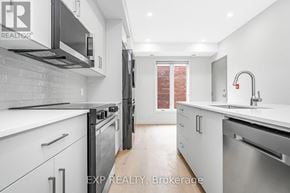Ottawa multi-family for rent - A modern kitchen with white cabinets and stainless steel appliances.