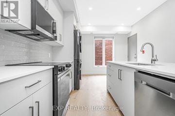 Ottawa multi-family for rent - A modern kitchen with white cabinets and stainless steel appliances.