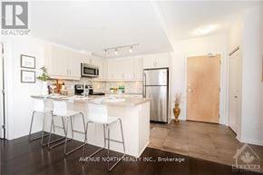 Ottawa condo for rent - A modern kitchen with white chairs and a wooden door.
