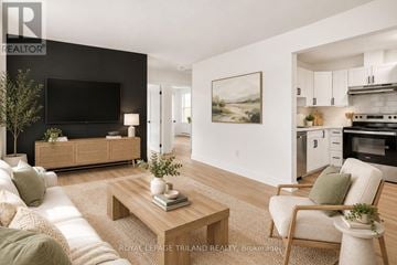 London East (East K) multi-family for rent - A modern living room with a flat screen TV, a sofa, a coffee table, and a painting on the wall.