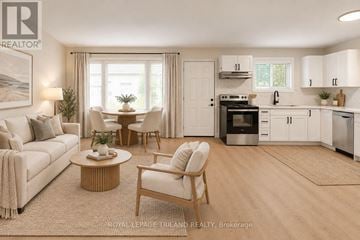 London East (East K) multi-family for rent - A well-lit, modern kitchen and living room with white furniture and a wooden coffee table.