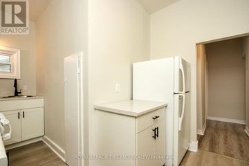 St. Thomas fourplex for rent - A white refrigerator in a kitchen with wooden cabinets.