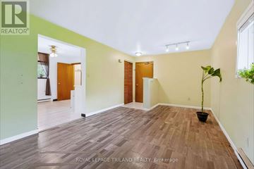 St. Thomas triplex for rent - A room with wooden flooring and white walls, with a plant in a black pot on the right side.
