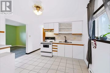 St. Thomas triplex for rent - A kitchen with white cabinets and a green wall.