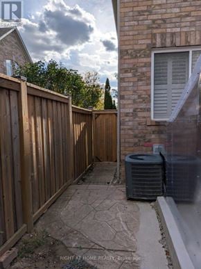 Mississauga (Churchill Meadows) apartment for rent - A wooden fence and a wall with a window and an air conditioner unit.