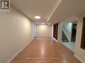 Mississauga (Churchill Meadows) apartment for rent - A spacious room with wooden flooring and a staircase in the background.