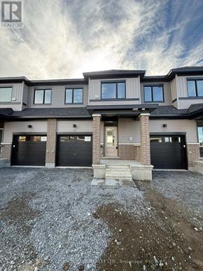 Ottawa townhouse for rent - A modern house with a grey roof and black garage doors.