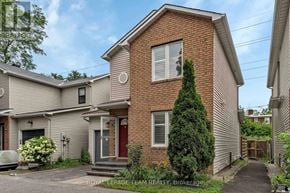 Ottawa apartment for rent - A house with a red door and a small garden in front.