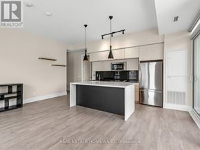 Toronto (Kensington-Chinatown) condo for rent - A modern kitchen with a large island and stainless steel appliances.