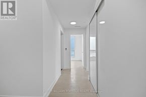 Toronto (Waterfront Communities) condo for rent - A long hallway with white walls and a door at the end.