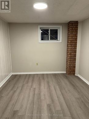 Vaughan (West Woodbridge) apartment for rent - A room with a brick column and wood flooring.