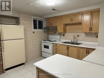 Vaughan (West Woodbridge) apartment for rent - A kitchen with a white counter top and wooden cabinets.
