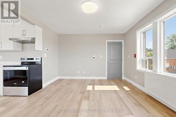 Hamilton (St. Clair) multi-family for rent - A kitchen with a stainless steel oven and wooden flooring.