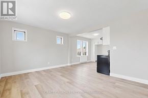 Hamilton (St. Clair) multi-family for rent - A spacious room with wooden flooring and a flat screen TV.