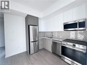 Kitchener condo for rent - A modern kitchen with stainless steel appliances and white cabinets.