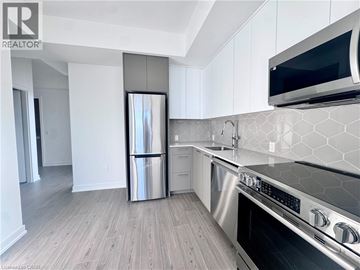 Kitchener condo for rent - A modern kitchen with a stainless steel refrigerator and oven.