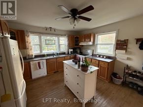 Prince Edward County (Hallowell Ward) apartment for rent - A kitchen with wooden cabinets and a white refrigerator.