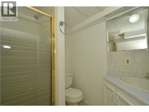 Calgary apartment for rent - A bathroom with a toilet, sink and mirror.
