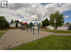 Calgary apartment for rent - A playground with a slide and swings in a residential area.
