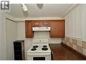 Calgary apartment for rent - A kitchen with a white stove and wooden cabinets.