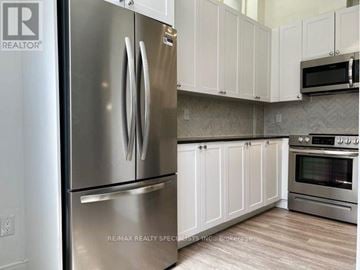 Toronto (Church-Yonge Corridor) condo for rent - A modern kitchen with a stainless steel refrigerator and white cabinets.