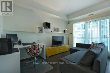 Toronto (Mimico) condo for rent - A living room with a grey couch and a yellow cabinet.