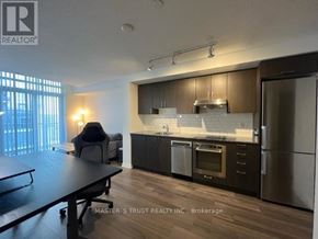 Toronto (Henry Farm) condo for rent - A modern kitchen with a dining table and a refrigerator.