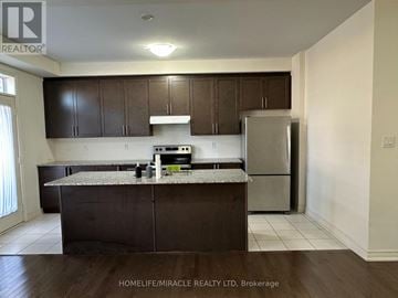 Brampton (Northwest Brampton) apartment for rent - A kitchen with brown cabinets and a granite countertop.