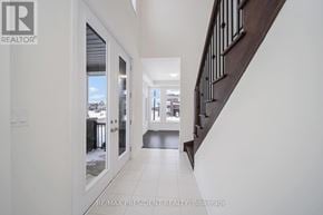Erin apartment for rent - A hallway with a staircase and a view of the outside through a glass door.