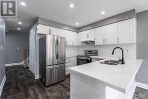 Whitby (Williamsburg) apartment for rent - A modern kitchen with stainless steel appliances and white countertops.