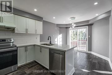 Whitby (Williamsburg) apartment for rent - A kitchen with white cabinets and a black stove top oven.