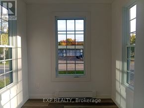 Ottawa apartment for rent - A room with a window showing a view of a street with cars and houses.
