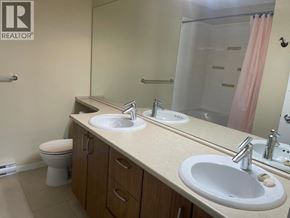 Coquitlam apartment for rent - A bathroom with a sink, toilet, and mirror.