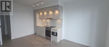 Mississauga (City Centre) condo for rent - A kitchen with white cabinets and a black stove top oven.