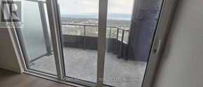 Mississauga (City Centre) condo for rent - A glass door leading to a balcony with a view of the city.