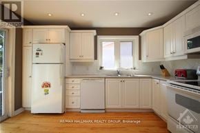 Ottawa triplex for rent - A clean, white kitchen with a refrigerator and cabinets.