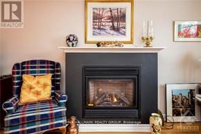Ottawa triplex for rent - A cozy living room with a fireplace, a chair, and pictures on the wall.