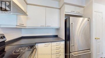 Toronto (Mimico) condo for rent - A kitchen with white cabinets and a stainless steel refrigerator.