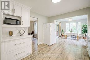 East Gwillimbury (Holland Landing) apartment for rent - A kitchen with a white fridge and a microwave above the counter.