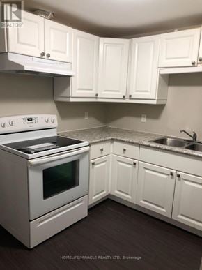 Barrie (Northwest) apartment for rent - A white kitchen with a stove, oven, and cabinets.