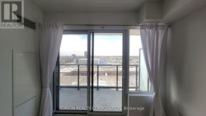 Pickering (Bay Ridges) condo for rent - A room with a view of the city through a large window.