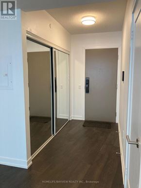 Toronto (Waterfront Communities) condo for rent - A hallway with a sliding door and a black mat on the floor.