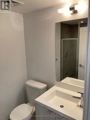 Toronto (Waterfront Communities) condo for rent - A white toilet sits next to a white sink in a small bathroom.