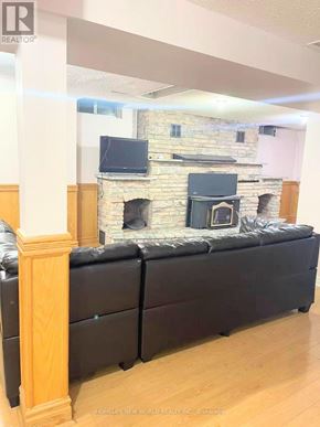Toronto (Milliken) apartment for rent - A black couch in front of a stone fireplace.