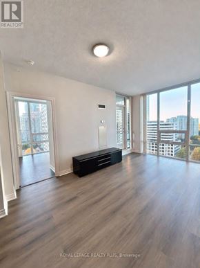Mississauga (Fairview) condo for rent - A spacious room with wooden flooring and a large window overlooking the city.