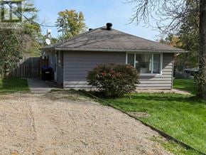 Ramara apartment for rent - A small house with a grey roof and a gravel driveway in front.