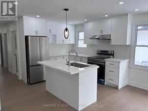 Ramara apartment for rent - A kitchen with white cabinets and a large island.